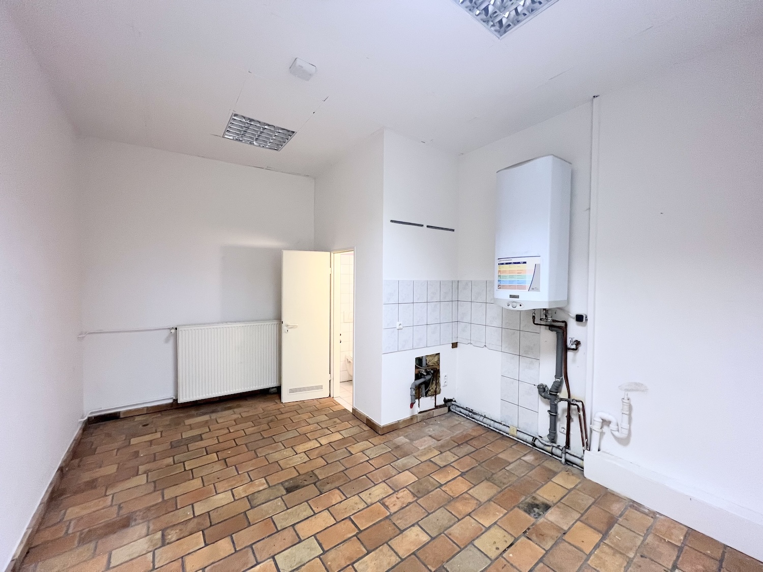 Das Ladenlokal in der Ponnstraße Ansicht mit Blick auf Heizung und Fliesenspiegel Küche