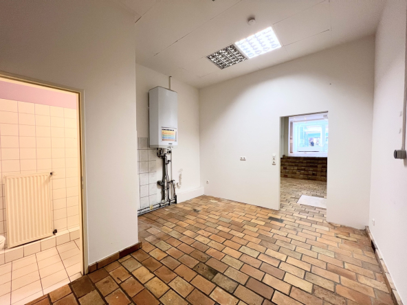Das Ladenlokal in der Ponnstraße Ansicht Lagerraum mit Blick auf Gäste WC und Etagenheizung, sowie Blick zur Treppe