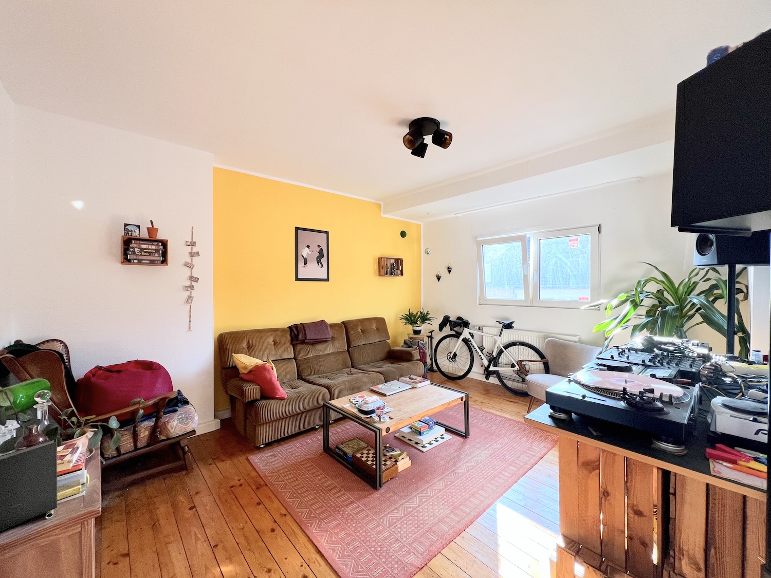 Wohnung im Frankenberger Viertel, Wohnzimmer mit Möbel und hellem Fenster sowie Holzdielenboden.