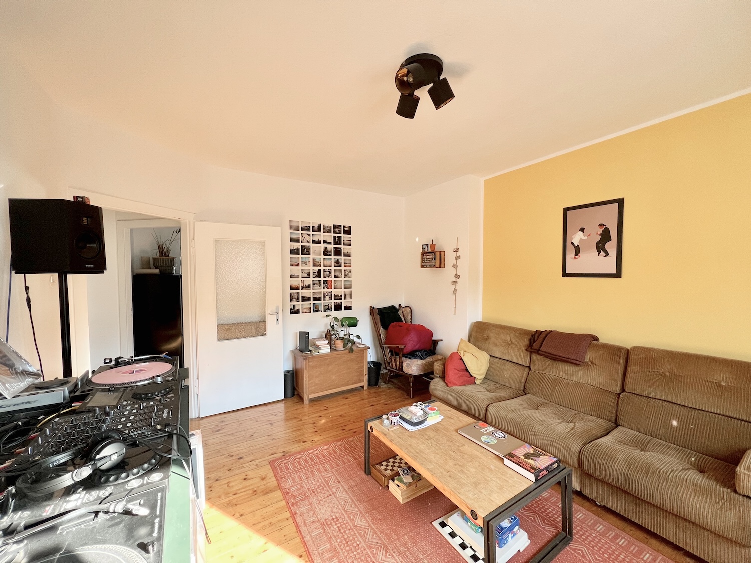 Wohnzimmer mit Möbeln, gelber Wand und Holzdielenboden