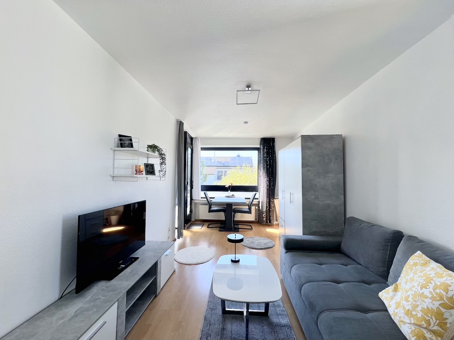 Wohnzimmer mit Tv, Tisch und Sofa