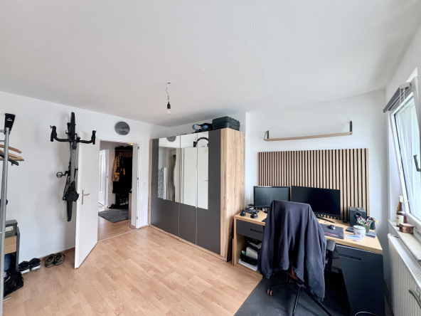 Büroraum mit Spiegelschrank, Stuhl und Bürotisch.