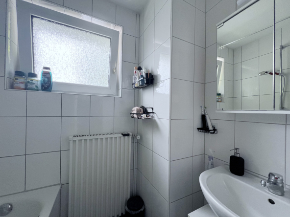 Badezimmer mit Dusche, Wanne und Tageslichtfenster, Waschbecken und Spiegelschrank