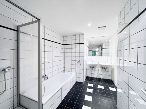 Wohnung in Kornelimünster mit blick auf Dusche und Badewanne, wände in weiss gefliest und Boden in schwarz