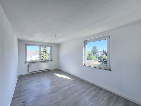 Hinteres Zimmer der Wohnung mit 2 Fenstern und Blick in den Garten