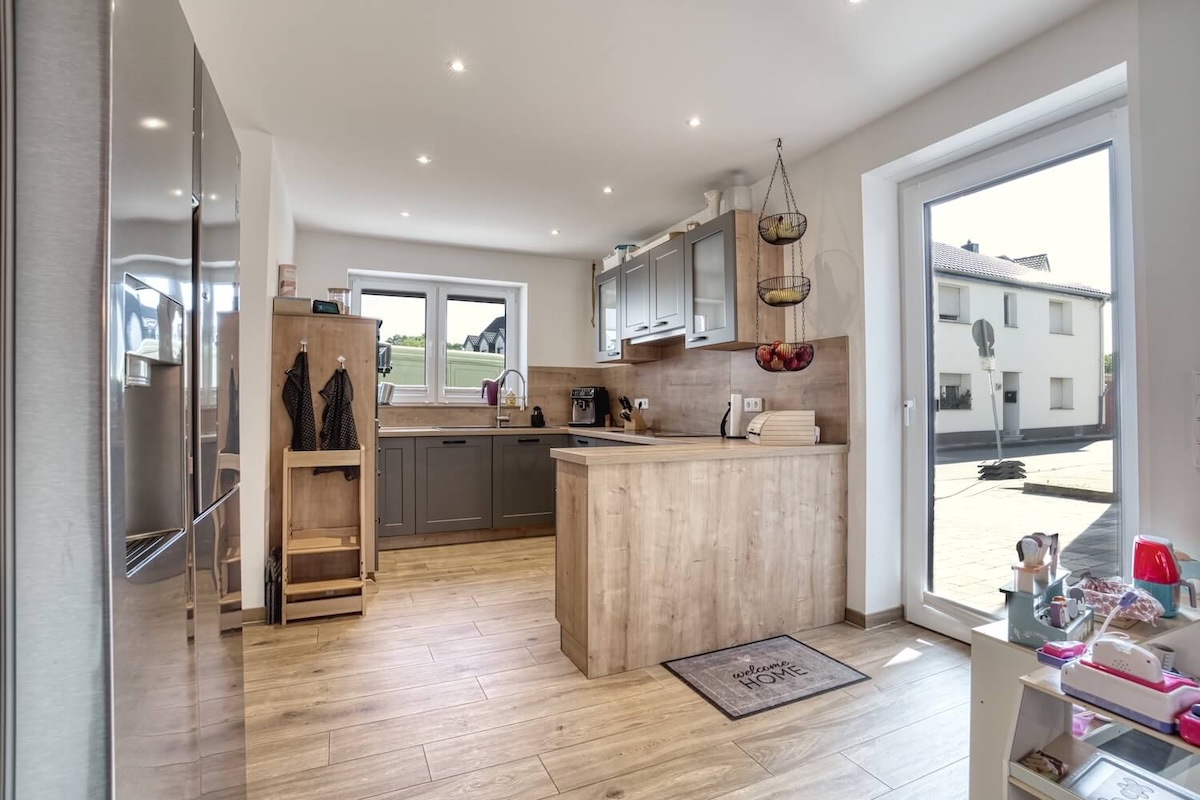 Küche mit Grossem Kühlschrank und Arbeitsplatte, sowie Türe nach draussen