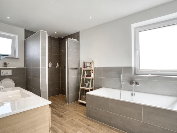 Badezimmer mit Fenster und Badewanne und Dusche