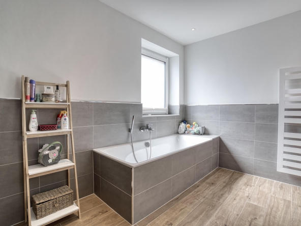 Badezimmer mit Badewanne und Handtuchwärmer