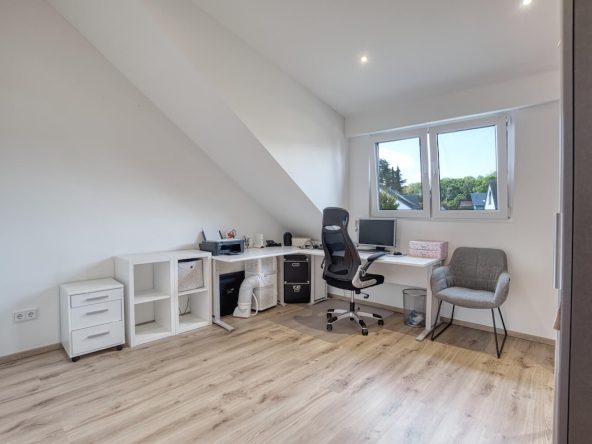 Büro mit Computer und Schreibtisch mit Stühlen