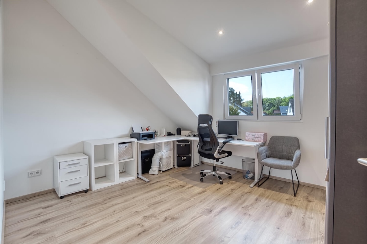 Büro mit Computer und Schreibtisch mit Stühlen