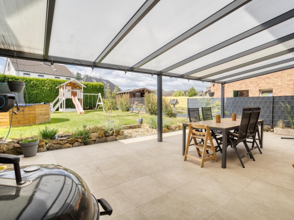 überdachte Terrasse mit Esstisch und Stühlen