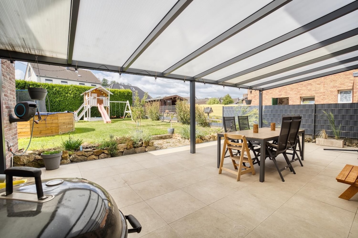 überdachte Terrasse mit Esstisch und Stühlen