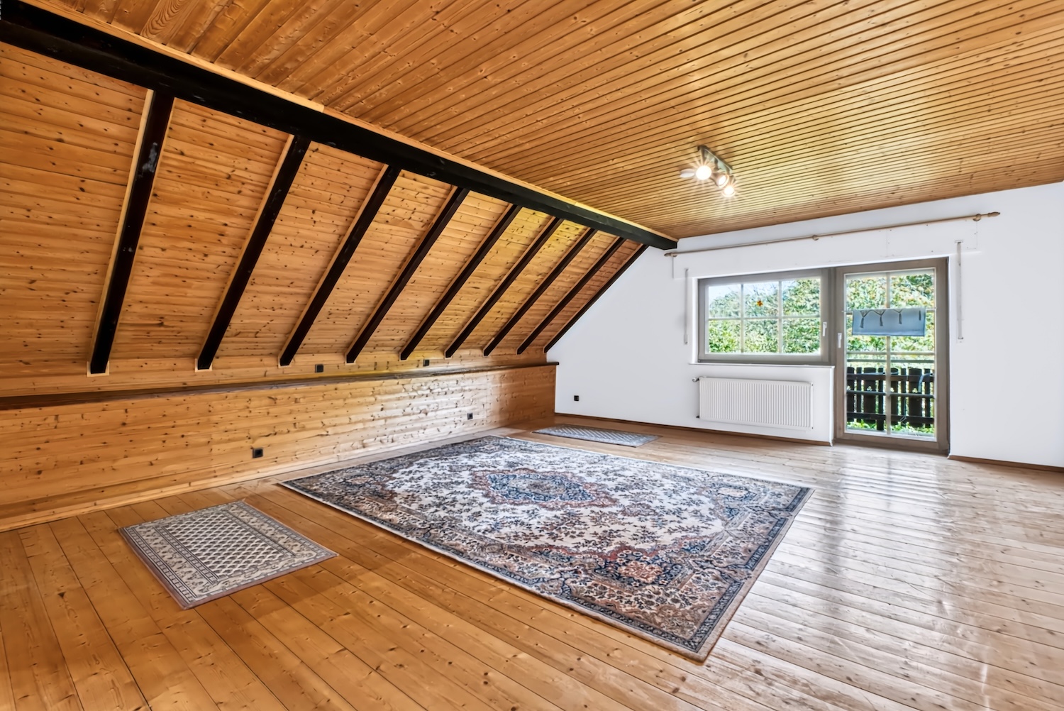 Elternschlafzimmer mit Holzboden und Teppich