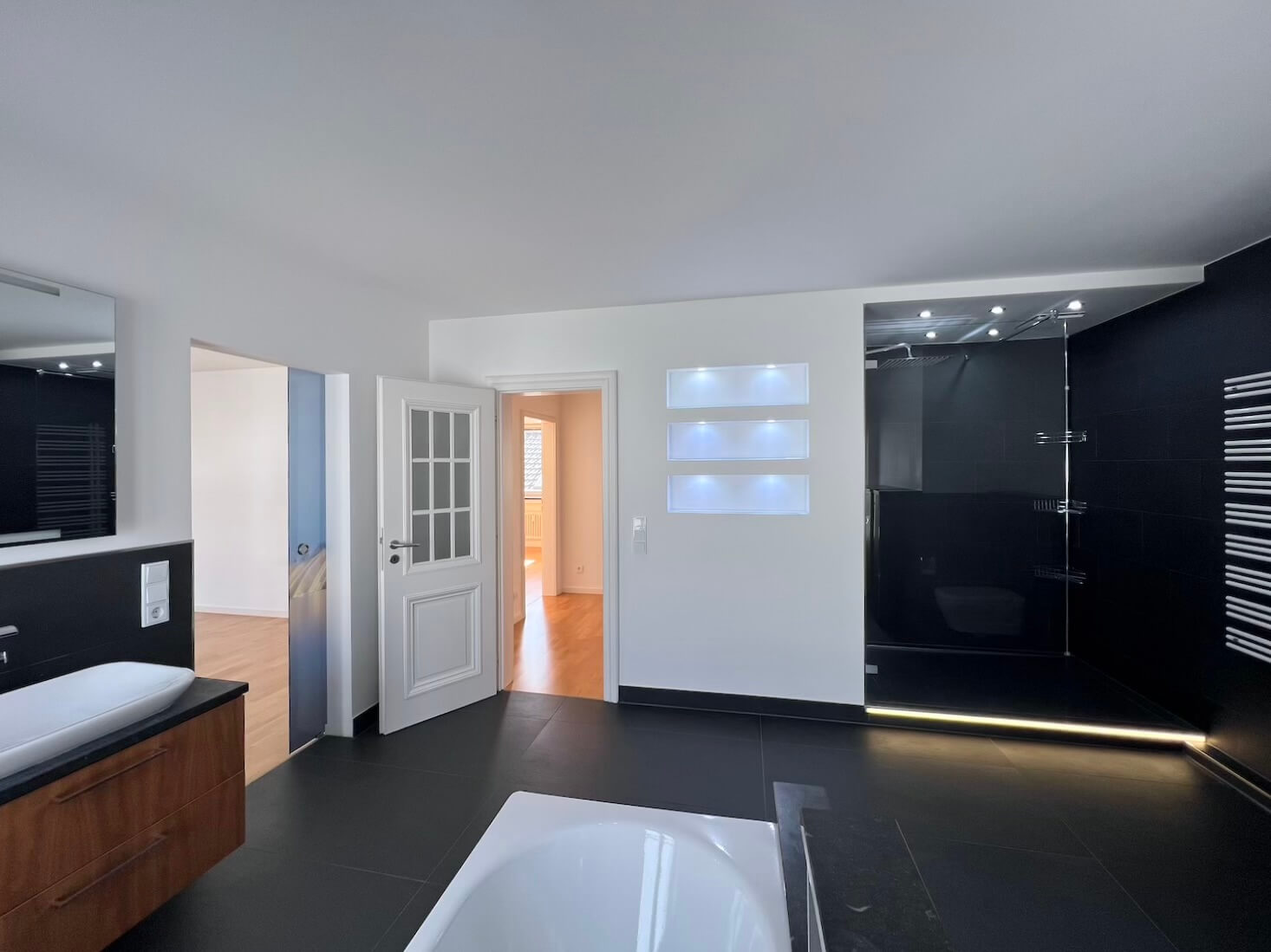Badezimmer mit Blick auf Türe und Eingang zum Schlafzimmer